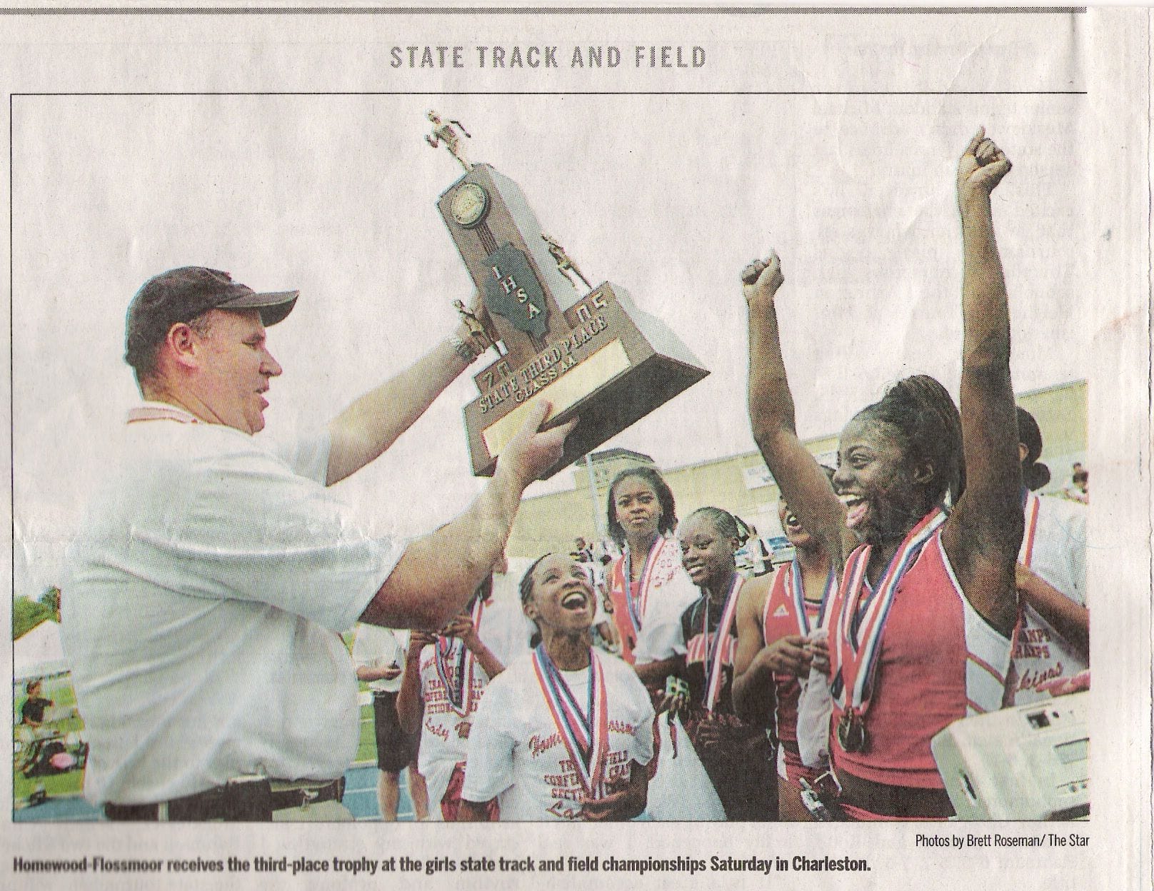newspaper clipping of Adigun receiving state track and field trophy
