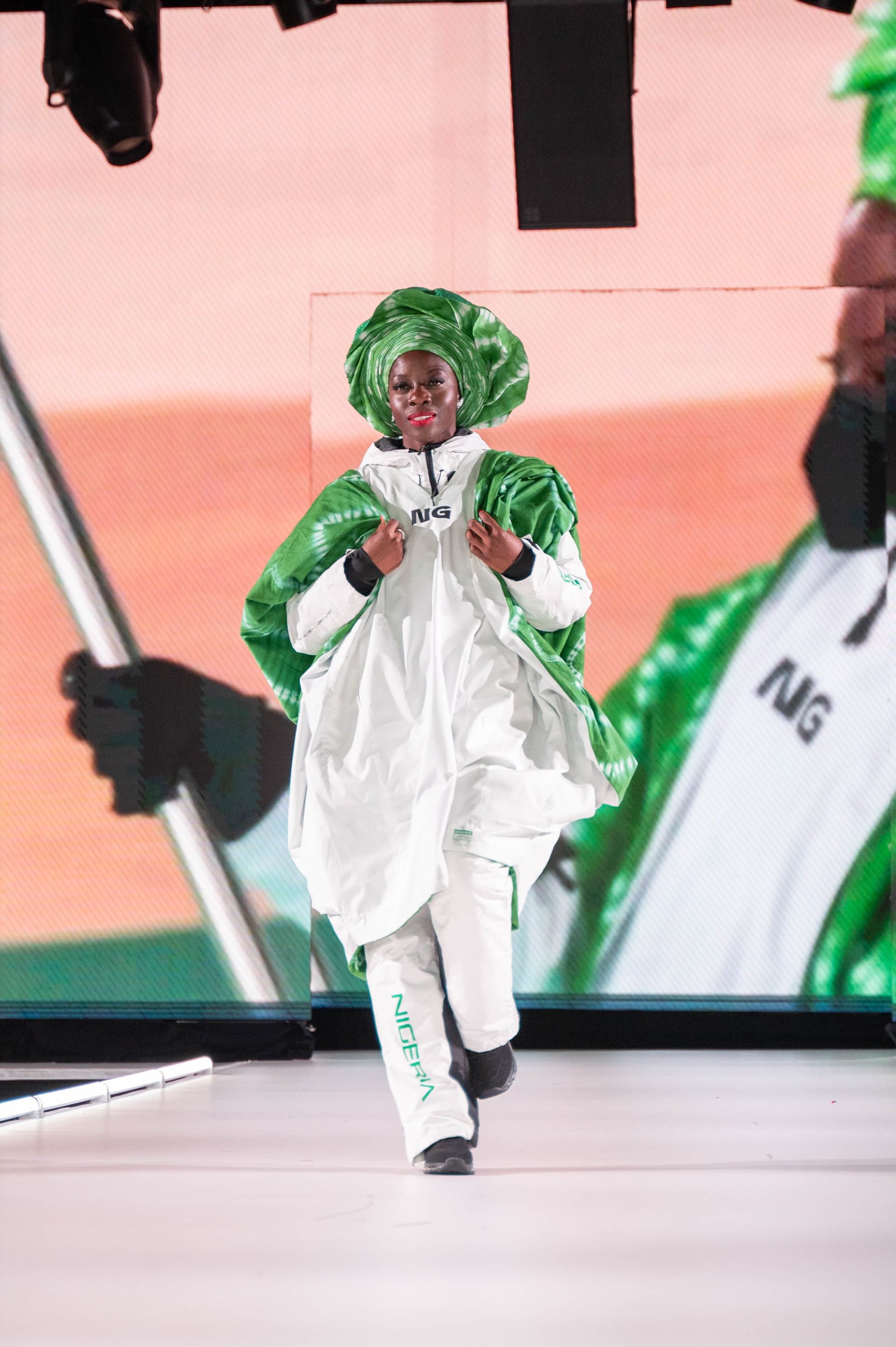 Adigun walking on stage in a Nigerian team outfit