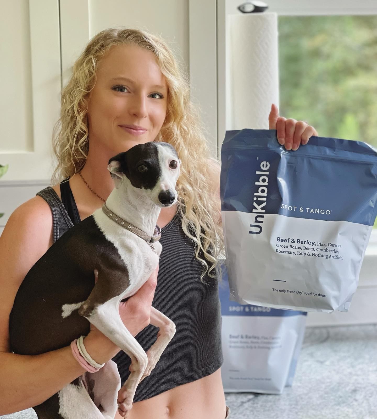 Another angle of Sandi holding her other dog and the bag of kibble