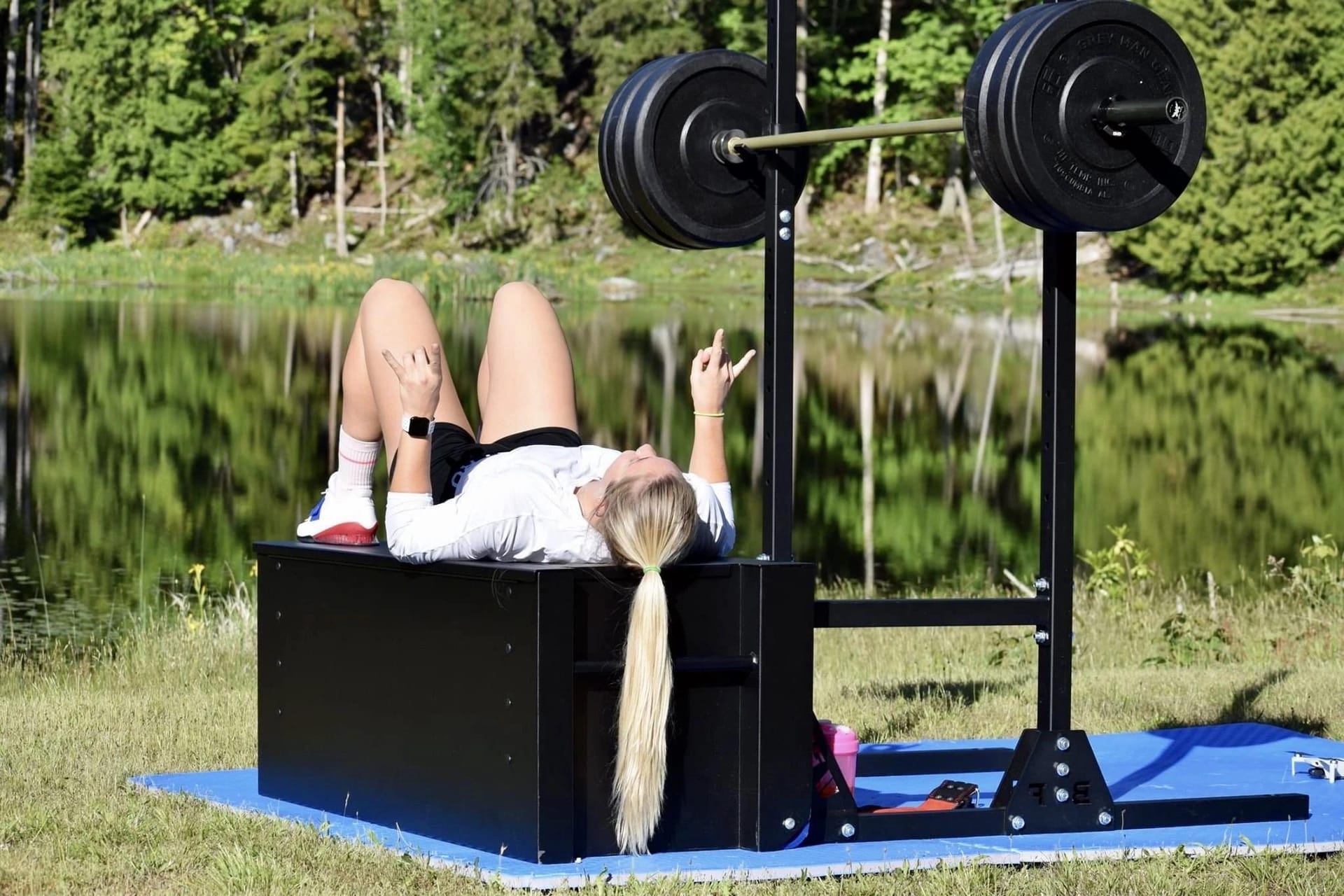 Mackenzie Stewart lying under a lakeside squat rack