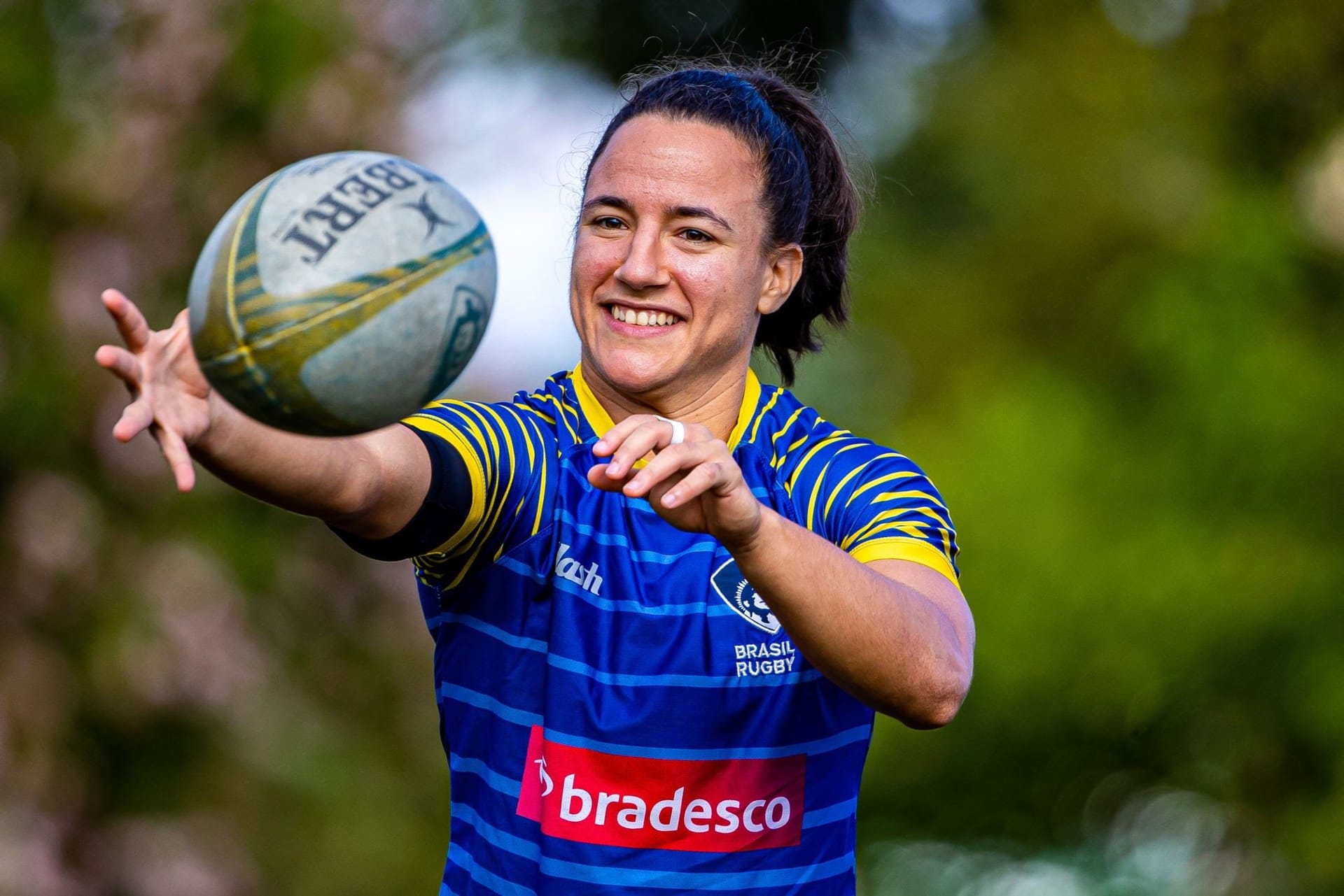 Isadora Cerullo catches a rugby ball on the field