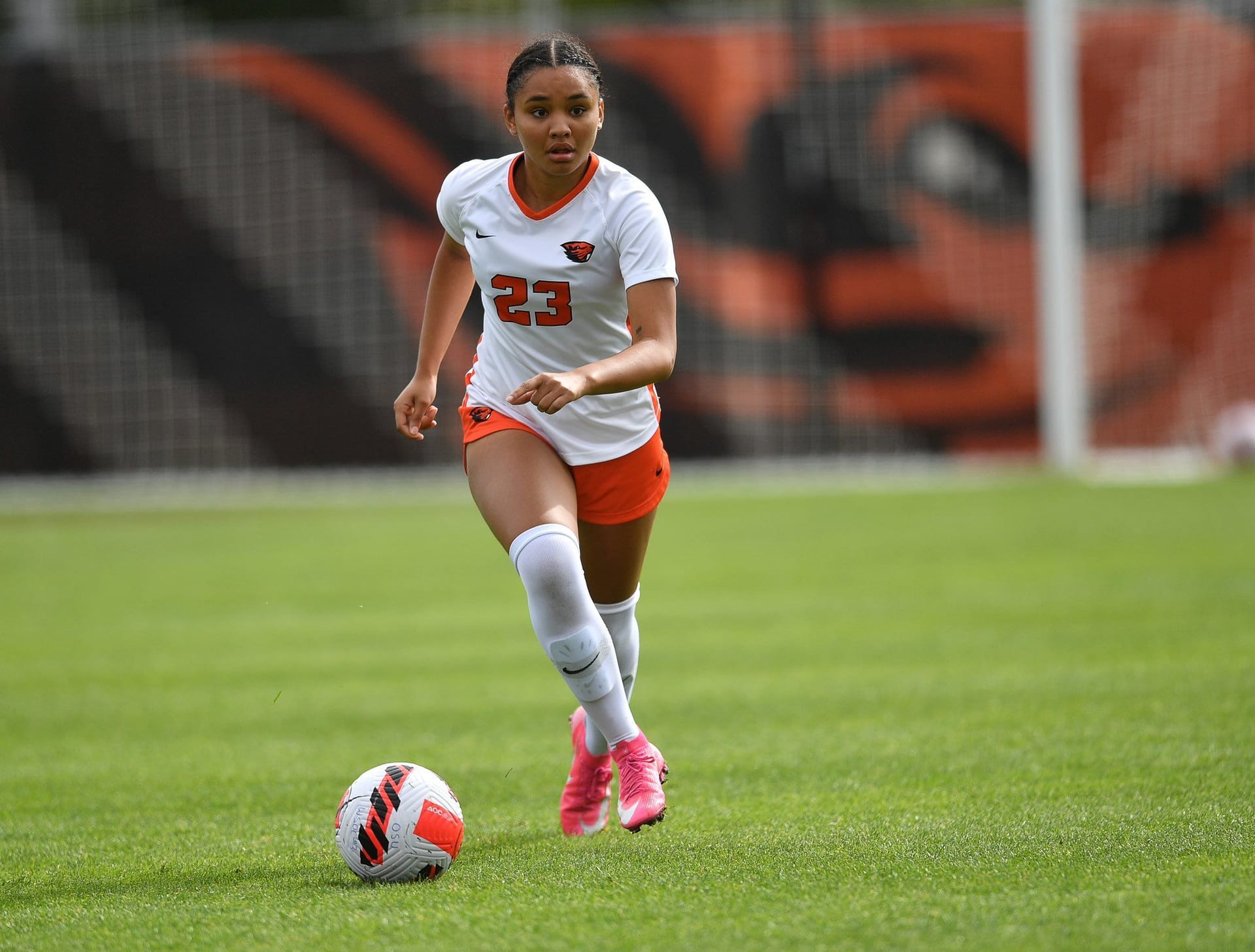 Skylar Herrera in uniform runs toward a soccer ball on the OSU field