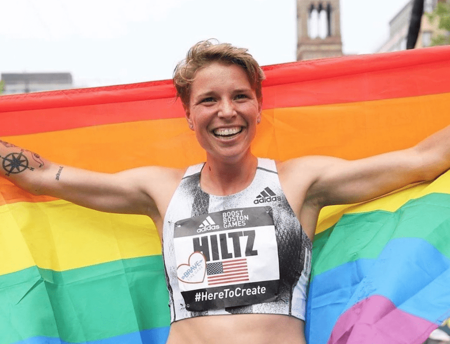 Nikki Hiltz holds rainbow pride flag at a marathon race