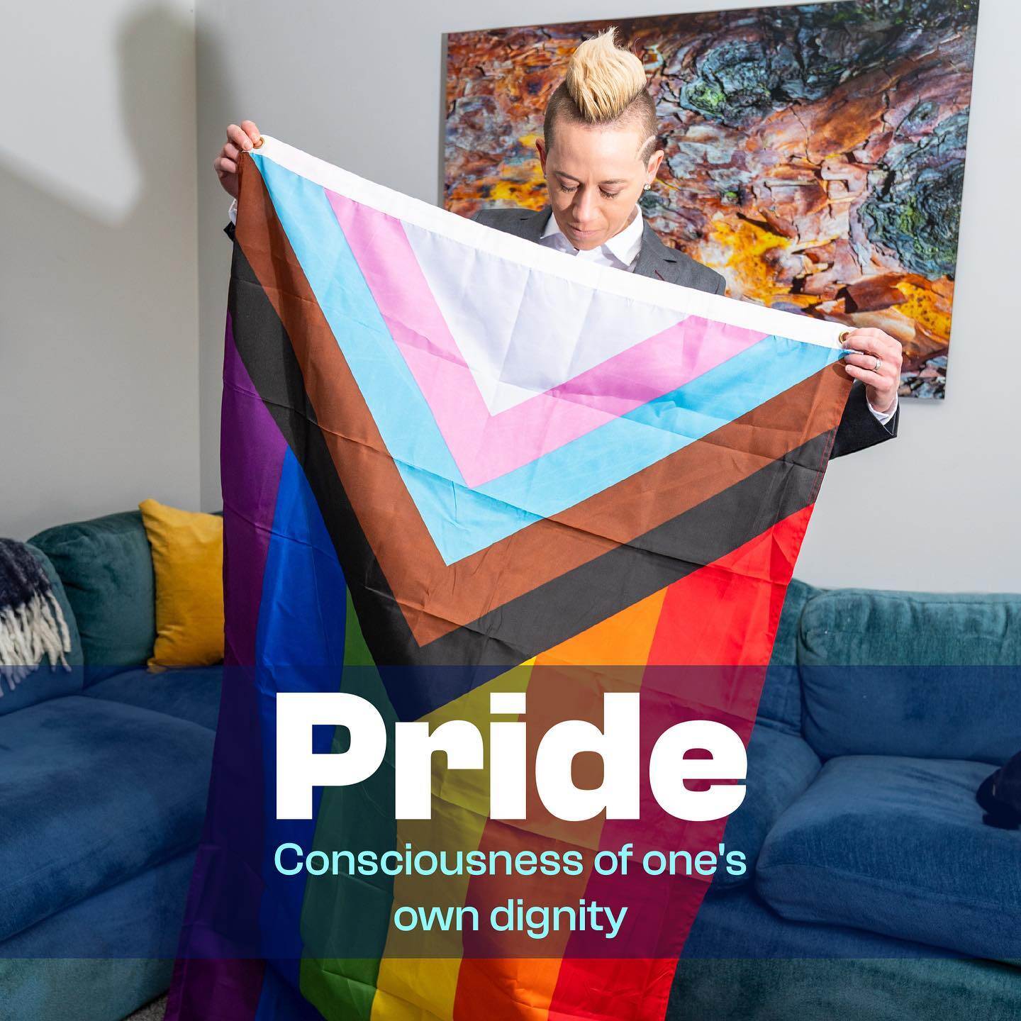 Joanna Lohman holds up a modern LGBTQ+ pride flag