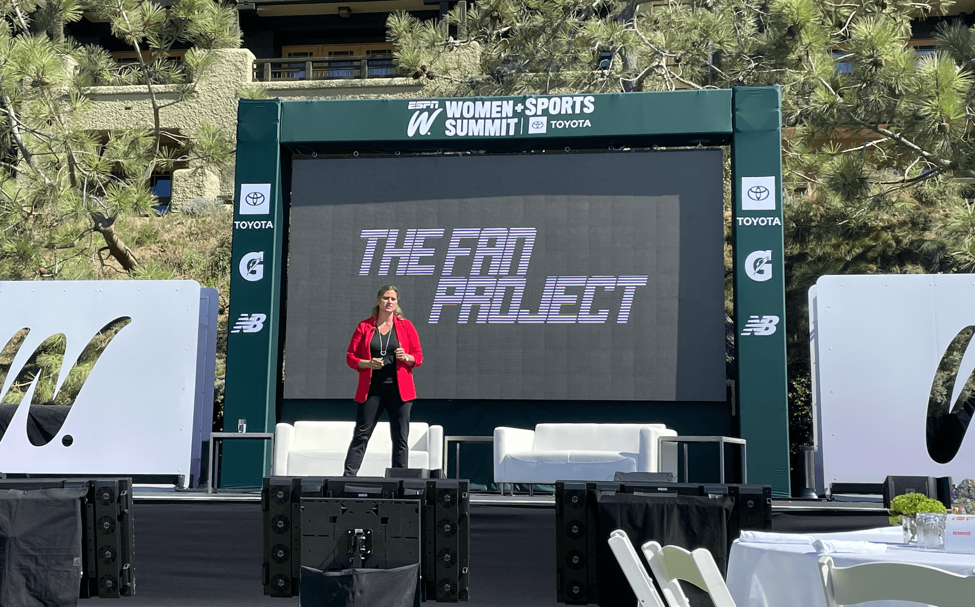 woman presents on stage at ESPN Women plus Sports Summit