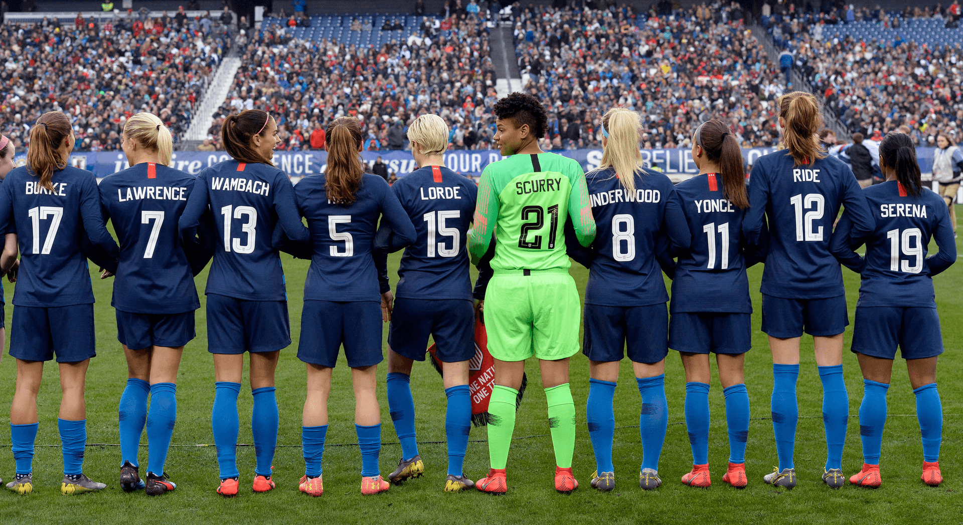 womens professional soccer team lined up on field at a game