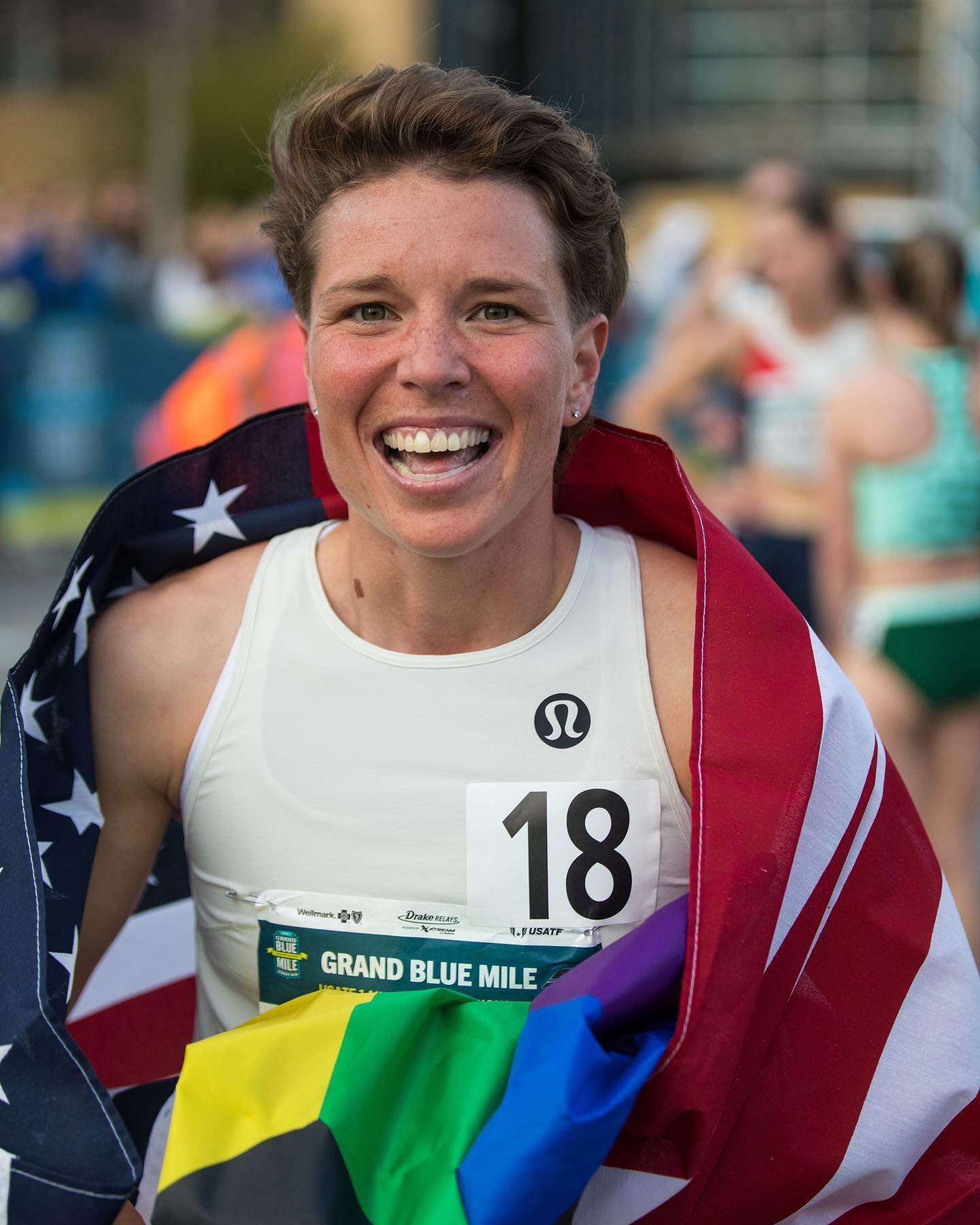 Nikki Hiltz runs a race carrying both US flag and pride flag