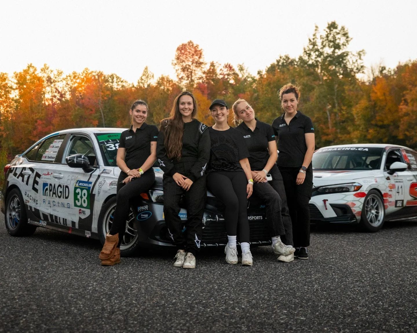 Erika Hoffman and team posing together on the hood of a racecar