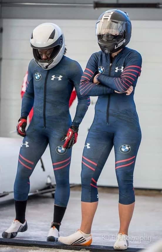 Adigun stands with a bobsled teammate for USA